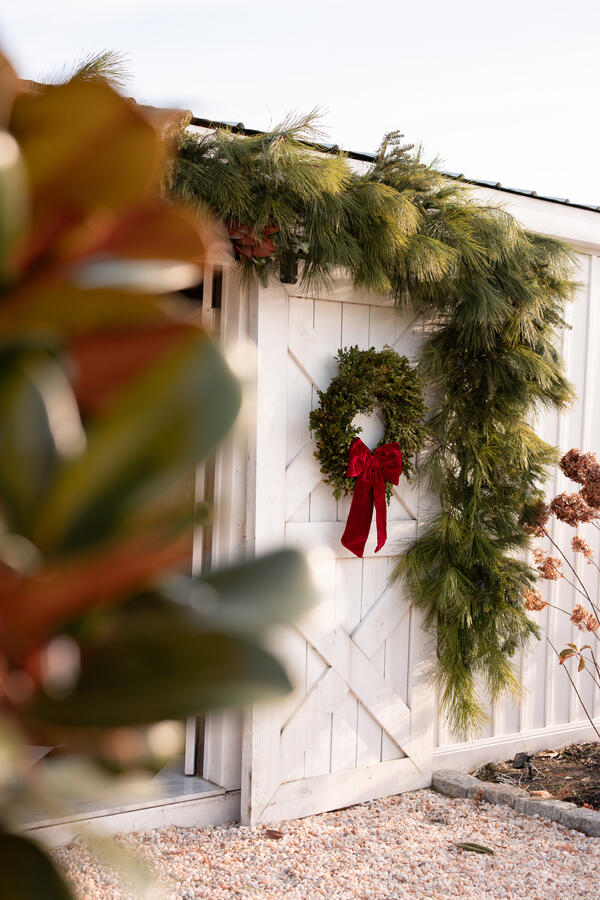 Fresh garland and wreath on barn door. Fresh garland and wreath on barn door.