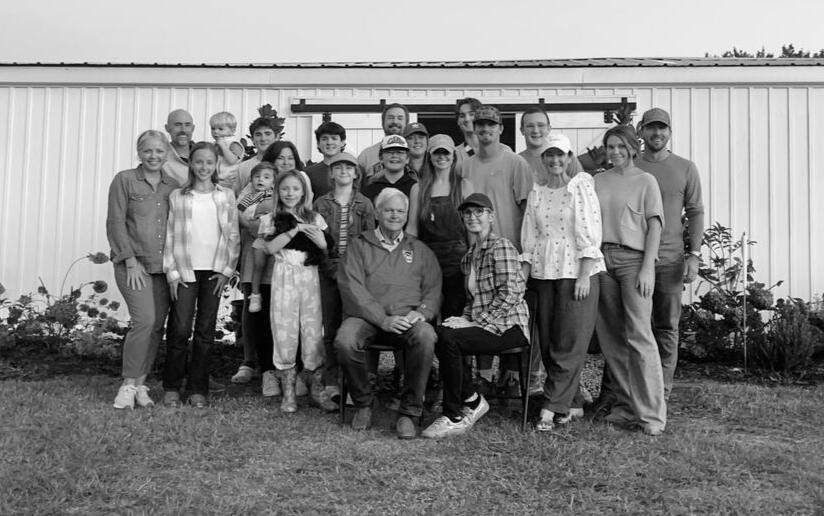 The whole family gathered in front of the white barn